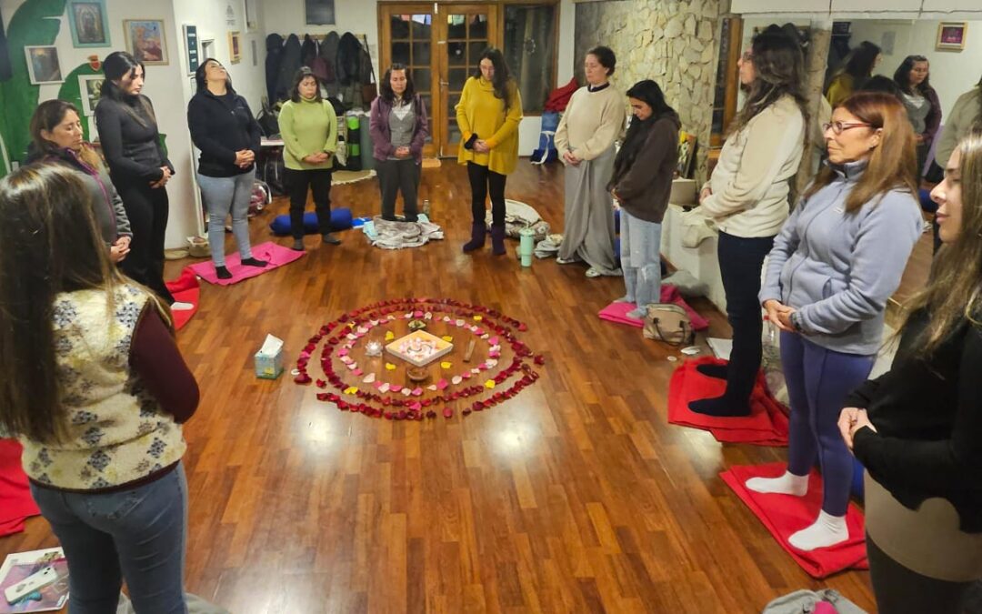 Mujeres participando en una ceremonia de Sanación de Útero y Rito del Útero con las manos sobre su propio útero.